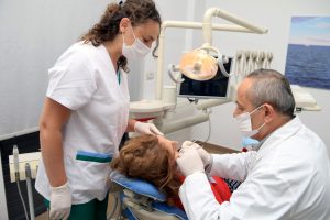 Dental team performing a patient examination